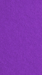 The surface of dark violet cardboard. Rough paper texture with cellulose fibers. Saturated color. Purple vertical background or wallpaper for phone or mobile. Macro