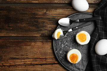 Tasty boiled chicken eggs on wooden table, flat lay. Space for text