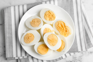 Tasty hard boiled eggs on ceramic plate, top view