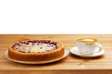 Homemade berry pie with yogurt filling and cup of coffee cappuccino on wooden table. Copyspace.