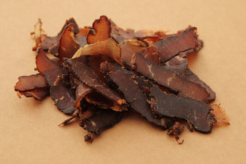 Biltong (dried meat) on a wooden board, this is a traditional food snack that can be found in South Africa.