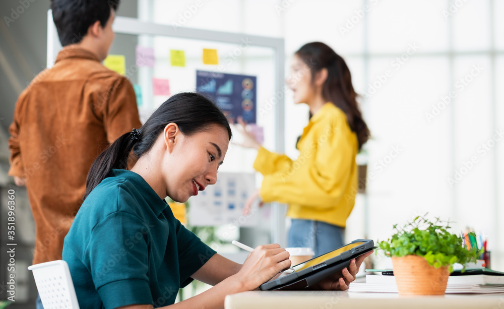 Aufkleber asian ux developer and ui designer using tablet testing mobile app interface design with colleagues at whiteboard in meeting at modern office.Creative digital development mobile app agency