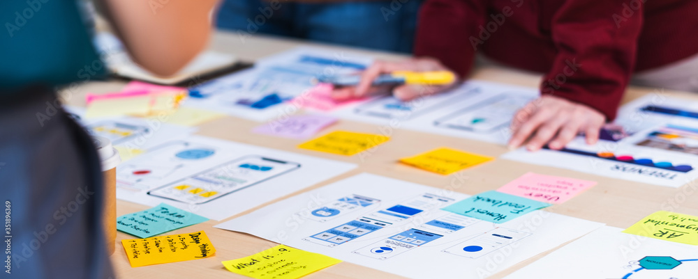 Aufkleber Close up ux developer and ui designer brainstorming about mobile app interface wireframe design on table with customer brief and color code at modern office.Creative digital development agency.panning