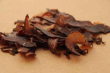 Biltong (dried meat) on a wooden board, this is a traditional food snack that can be found in South Africa.