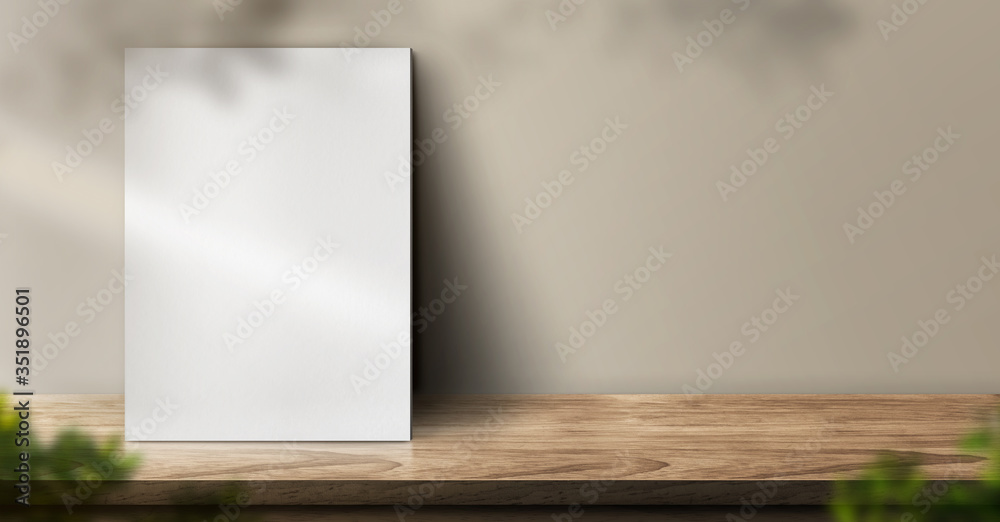 Poster blank poster on wood table background with sunlight window create leaf shadow on wall with blur indo