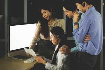 Beautiful Asian women and Thai women. She wears formal dresses and headphones. She was sitting in front of the computer, looking at the document, and there was a sorrowful and sad expression.