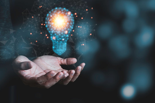 Hand holding the virtual light bulb with brain. Creative new business idea concept.