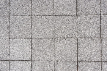 画面いっぱいに敷き詰められた正方形の灰色の煉瓦を正面から写した写真