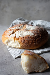 Wheat bread with a break on a light gray background on a wooden white delivery with textiles. The texture of the bread.The concept of healthy eating. Gluten-free. Advertising a bakery. Copy space
