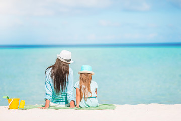 Beautiful mother and daughter at Caribbean beach enjoying summer vacation.