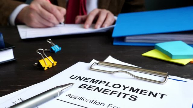 Unemployment benefits application form and manager in the office.