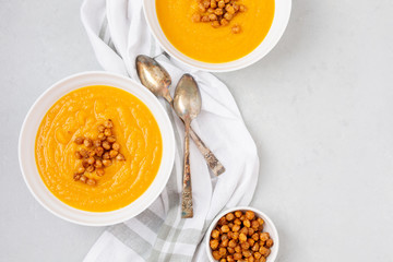 Homemade Butternut Squash Soup in White Bowl on Gray background; Roasted Chickpea Garnish
