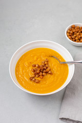 Homemade Butternut Squash Soup in White Bowl on Gray background; Roasted Chickpea Garnish