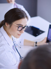 Serious medical team using a laptop in a bright office