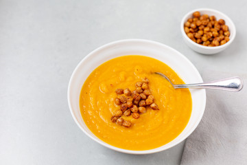 Homemade Butternut Squash Soup in White Bowl on Gray background; Roasted Chickpea Garnish