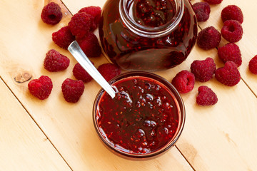 fresh homemade raspberry jam in a jar, rustic style.