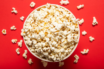 Fototapeta na wymiar Delicious popcorn on a red background. View from above