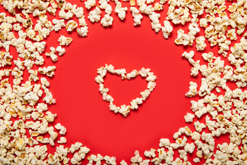 Delicious popcorn on a red background. View from above