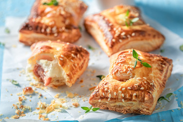 Hot sausage roll with puff pastry on blue table