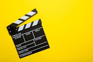 Fototapeta na wymiar Movie clapper on a yellow background, top view. Place for text