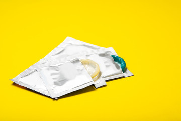 Condoms on a yellow background. Colored condoms. Safe sex