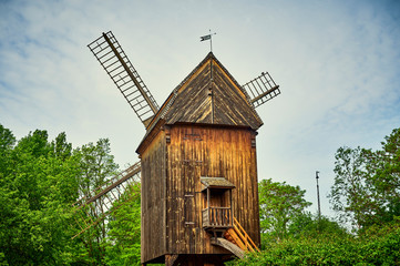 Fototapeta na wymiar Historic and restored windmill in Berlin, Germany, between trees in spring.