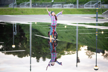 水溜まりで自転車に乗る女の子
