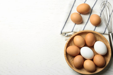 Chicken eggs on white wooden table, flat lay. Space for text
