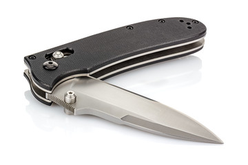 Lying open folding pocket knife with satin blade and black composite plastic cover plates on steel handle isolated on white background with reflection on glossy surface. Pocket knife close-up image