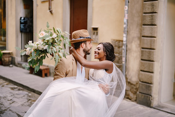 Interracial wedding couple. Wedding in Florence, Italy. Caucasian groom circling African-American...