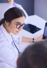 Serious medical team using a laptop in a bright office