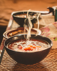 On the table in the village hot borscht, steam is coming over the soup