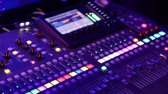 mixer console of the sound engineer near the stage to the performance of a musical group, close-up