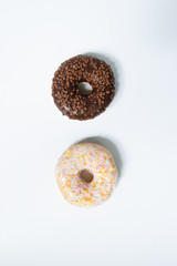 Donut day. Two bright colored donuts with colorful sprinkles on white background. Copy space, close-up