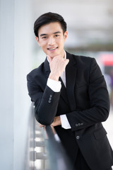 Asian business young man in black suit smiling