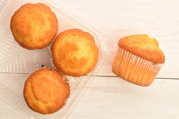 Tasty sweet muffins, close-up, on a painted wooden table.