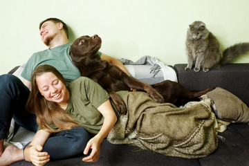 Funny crazy couple staying home with pet dog labrador retriever and cute cat
