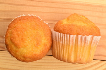 Tasty sweet muffins, close-up, on a wooden table.