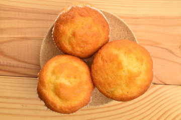 Tasty sweet muffins, close-up, on a wooden table.