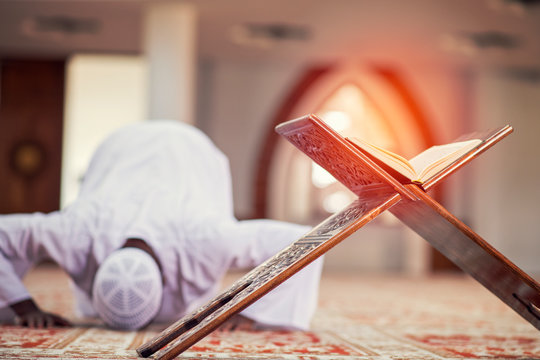 Religious black muslim man praying inside the mosque
