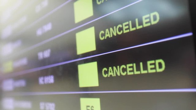 Flights cancelled and delayed on airport departure board due to covid-19 pandemic. Coronavirus causing disruption in air transport with airlines cancelling service. Travel and vacation cancellation