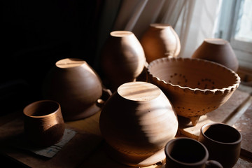 Clay plates,bowls,cups in the rays of the setting sun.