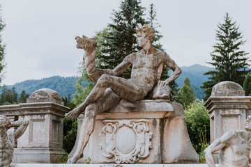 Fototapeta na wymiar Statue in Peles Castle garden, Sinaia, Romania. Discover Romania concept