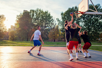 Group Of Young Friends Playing Basketball Match