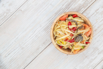 Thai papaya salad on vintage wood table