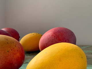 Mangoes in Woven Bowl on Wood Background