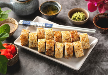 a portion sushi rolls on a plate on the table, close-up