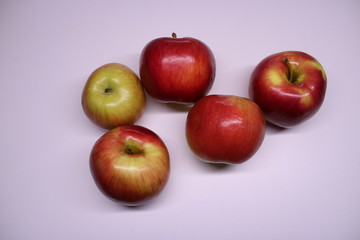 Five red-green apples on a white background.