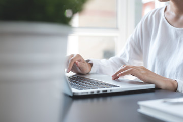 Business woman working on laptop computer searching internet from modern home office