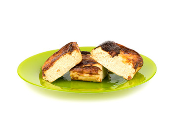 Three pieces of cottage cheese casserole on a green plate over a white background.